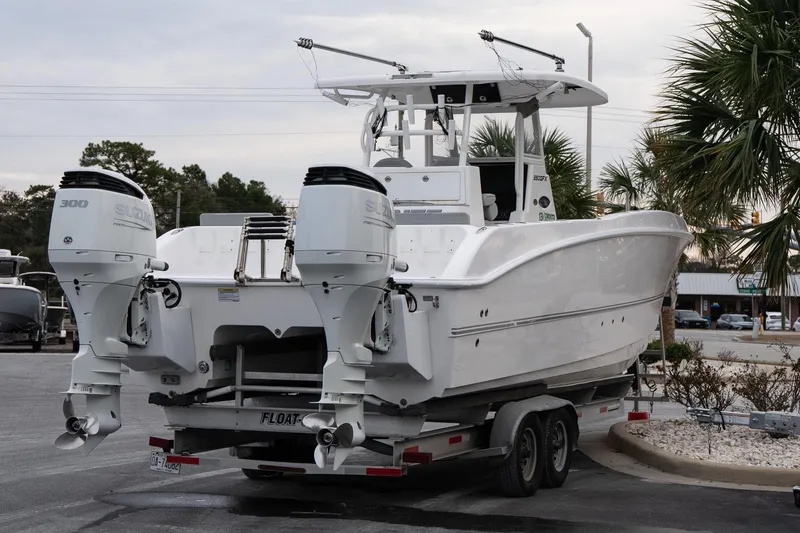 Slide: The Image of 2023 Twin Vee 280 GFX CC boat on trailer with dual Suzuki engines. - 6