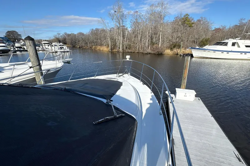 Slide: The Image of 1999 Carver 530 Voyager Pilothouse docked by a serene river with surrounding trees. - 16