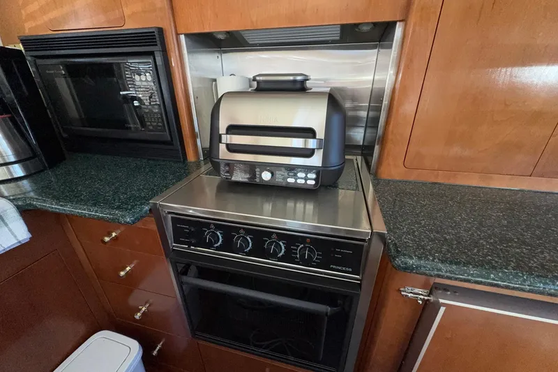 Slide: The Image of Kitchen area in a 1999 Carver 530 Voyager Pilothouse with appliances and wooden cabinetry. - 28