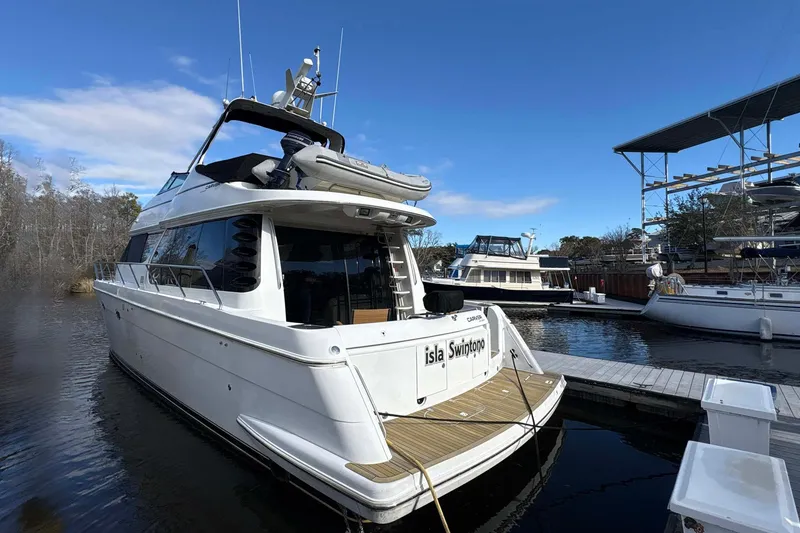 Slide: The Image of 1999 Carver 530 Voyager Pilothouse yacht docked at marina under clear blue sky. - 3