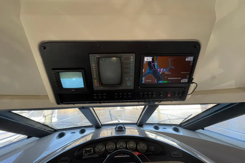 Slide: The Image of 1999 Carver 530 Voyager Pilothouse dashboard with navigation screens and controls. - 35