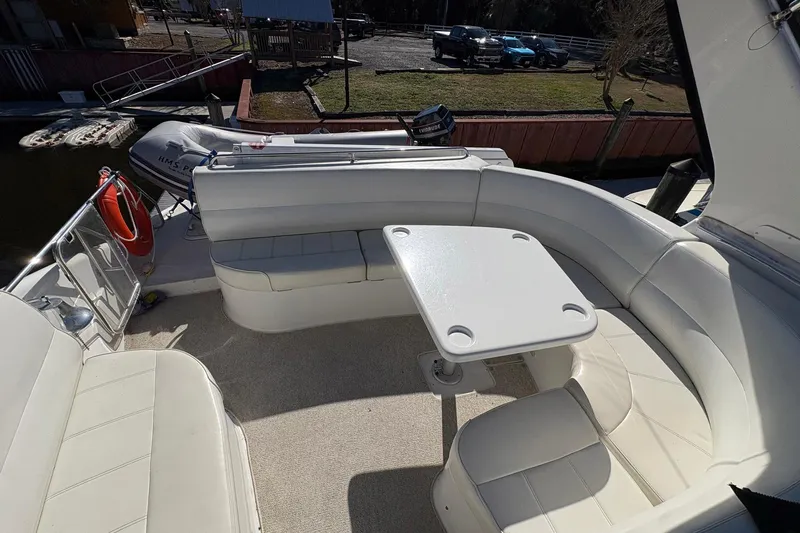 Slide: The Image of 1999 Carver 530 Voyager Pilothouse boat with white seating and table on deck. - 54