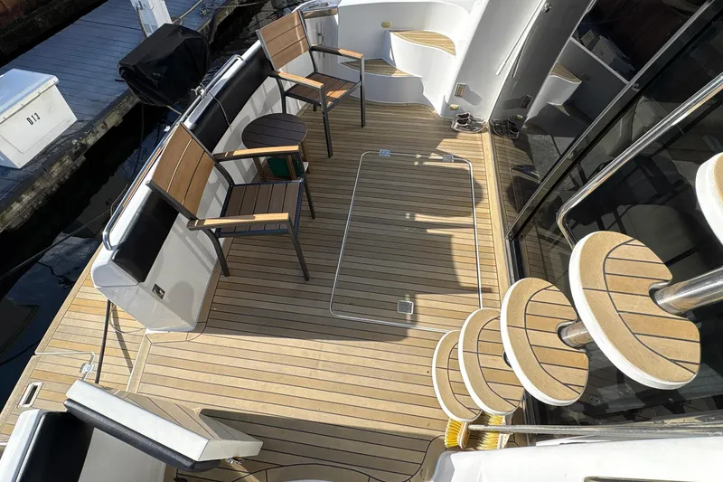 Slide: The Image of 1999 Carver 530 Voyager Pilothouse yacht deck with wooden chairs and spiral staircase. - 11