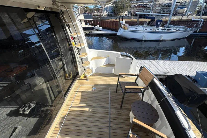 Slide: The Image of 1999 Carver 530 Voyager Pilothouse yacht deck with seating and water view. - 12