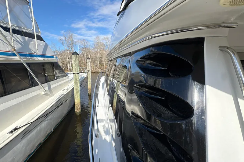 Slide: The Image of 1999 Carver 530 Voyager Pilothouse yacht docked beside another boat. - 13