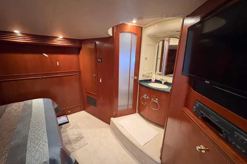 Slide: The Image of 1999 Carver 530 Voyager Pilothouse interior with wood paneling, bathroom, and TV. - 38