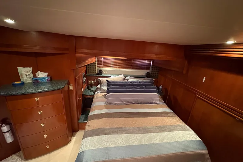 Slide: The Image of Luxurious bedroom in 1999 Carver 530 Voyager Pilothouse yacht with wood paneling and cozy bedding. - 39