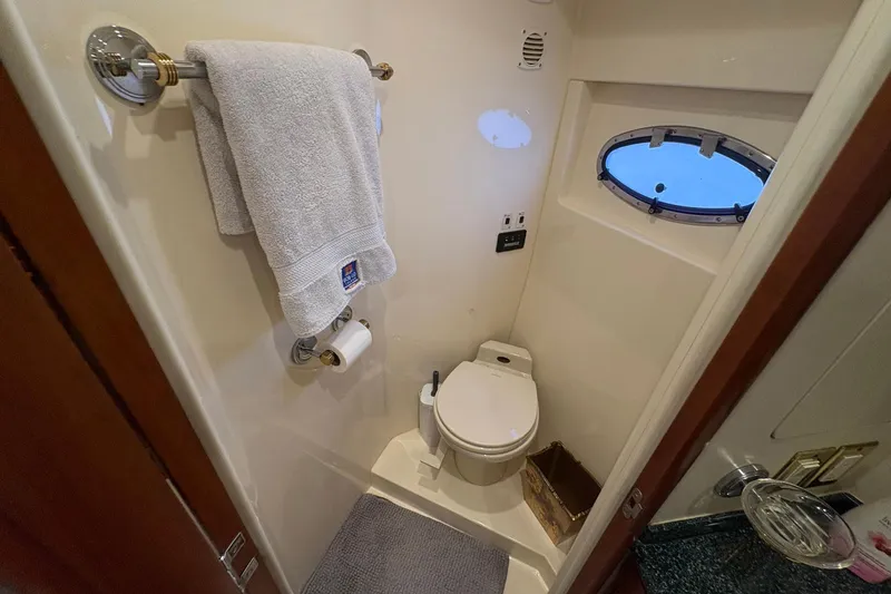 Slide: The Image of Bathroom interior of 1999 Carver 530 Voyager Pilothouse yacht with towel and porthole window. - 42