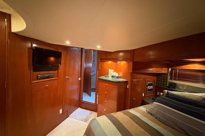 Slide: The Image of Luxurious 1999 Carver 530 Voyager Pilothouse bedroom with wood paneling and modern amenities. - 44