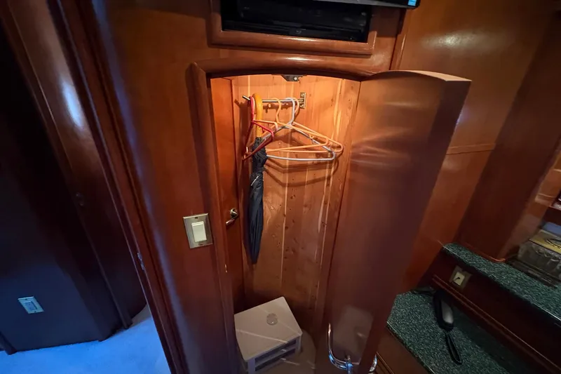 Slide: The Image of 1999 Carver 530 Voyager Pilothouse wooden closet with hangers and umbrella. - 48