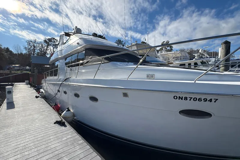 Slide: The Image of 1999 Carver 530 Voyager Pilothouse yacht docked under a partly cloudy sky. - 8