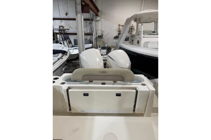 Slide: The Image of 2015 Cobia 296 Center Console boat in storage with dual engines. - 10