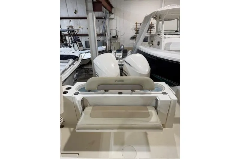 Slide: The Image of 2015 Cobia 296 Center Console boat with dual engines in a storage facility. - 11