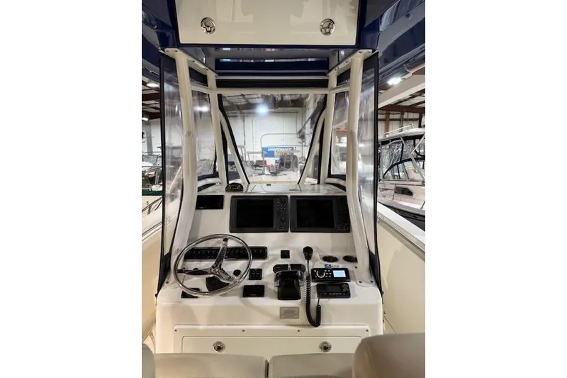 Slide: The Image of 2015 Cobia 296 Center Console boat dashboard with steering wheel and navigation controls. - 3