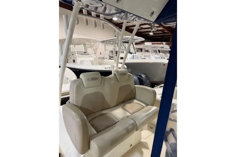 Slide: The Image of 2015 Cobia 296 Center Console boat interior with cushioned seating in a showroom. - 4
