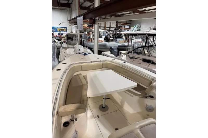 Slide: The Image of 2015 Cobia 296 Center Console boat interior with seating and table in showroom. - 5
