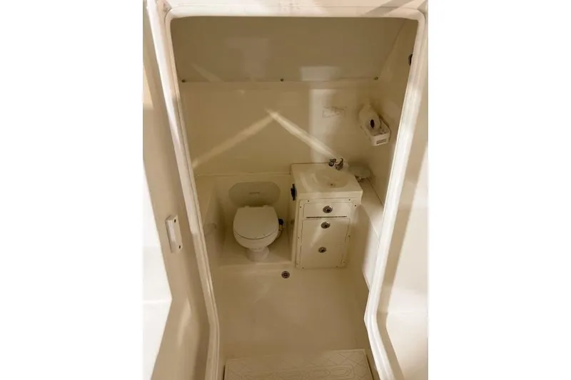 Slide: The Image of 2015 Cobia 296 Center Console boat bathroom with toilet and sink. - 8