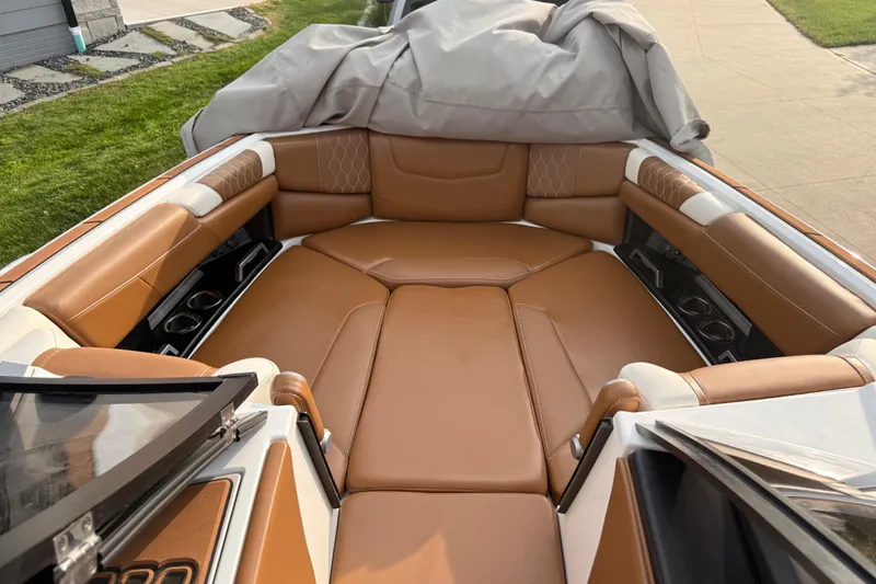 Slide: The Image of 2022 Malibu M220 boat interior with modern dashboard and tan leather seating. - 11