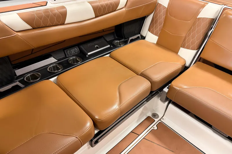 Slide: The Image of 2022 Malibu M220 boat interior with tan leather seats and cup holders. - 12