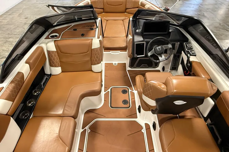 Slide: The Image of 2022 Malibu M220 boat interior with luxurious brown leather seating and modern dashboard. - 14
