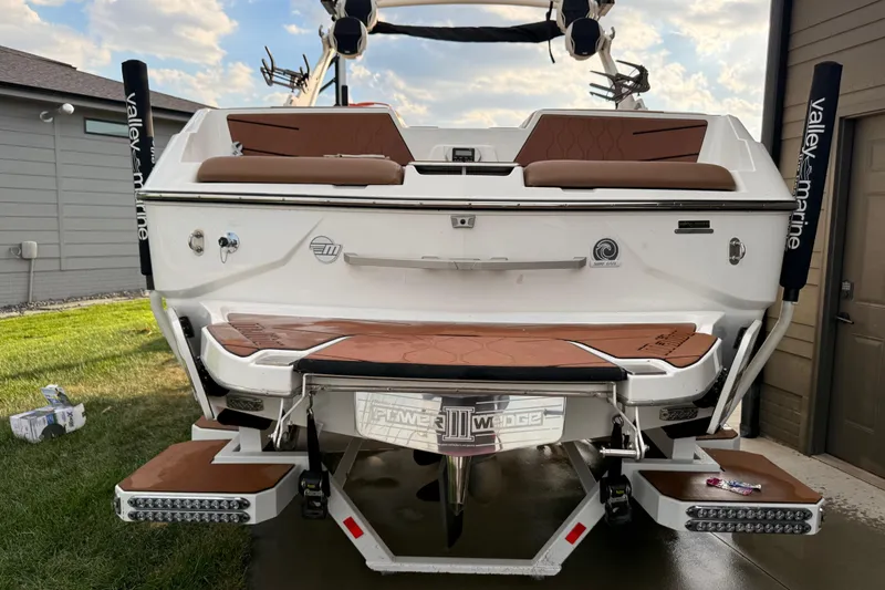 The Image of 2022 Malibu M220 boat in a warehouse on a trailer. - 4
