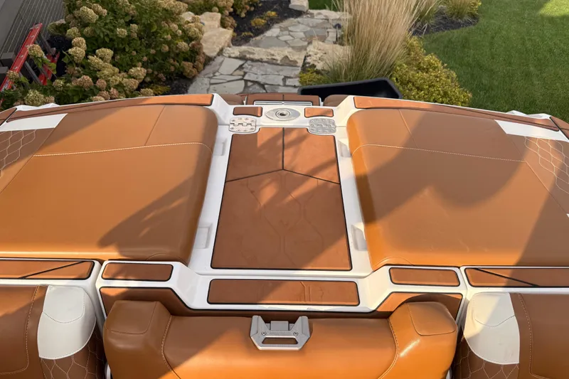 Slide: The Image of 2022 Malibu M220 boat in a spacious indoor showroom, showcasing sleek design and modern features. - 6