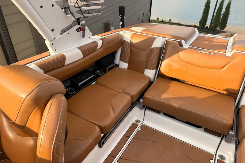 Slide: The Image of 2022 Malibu M220 boat in a warehouse, showcasing rear seating and deck features. - 7