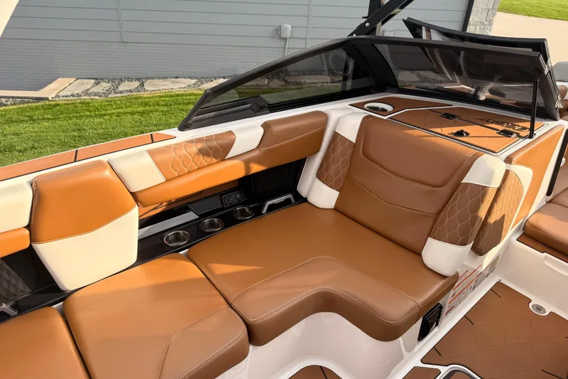 Slide: The Image of 2022 Malibu M220 boat interior with tan leather seating and sleek design. - 9