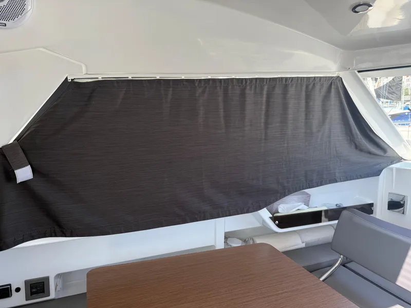 Slide: The Image of Interior of 2021 Beneteau Antares 8 with curtain and seating area. - 13