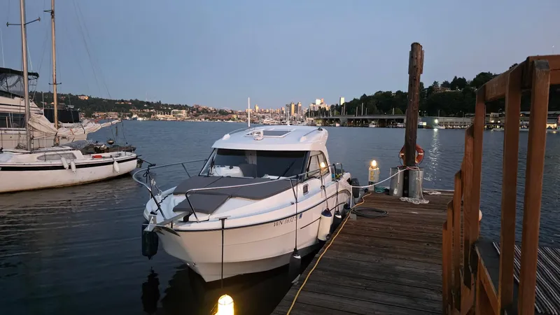 Slide: The Image of 2021 Beneteau Antares 8 docked at a serene waterfront during twilight. - 2