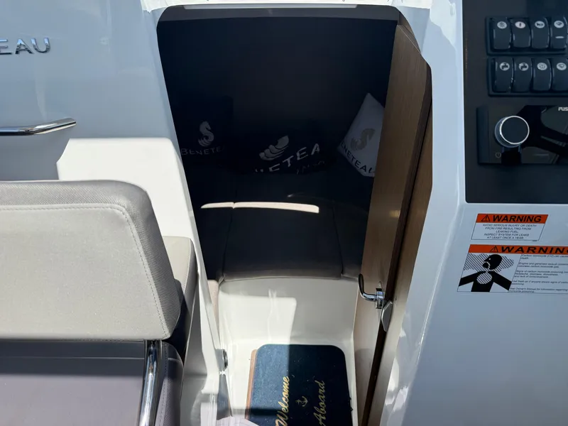 Slide: The Image of Interior cabin view of 2021 Beneteau Antares 8 boat with seating and warning labels. - 22