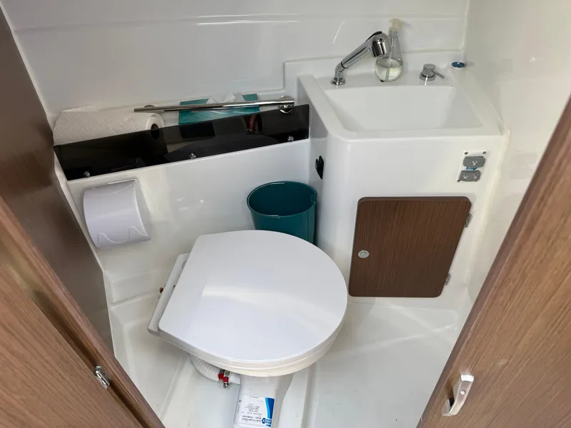 Slide: The Image of Compact bathroom in 2021 Beneteau Antares 8 boat with toilet, sink, and storage. - 24