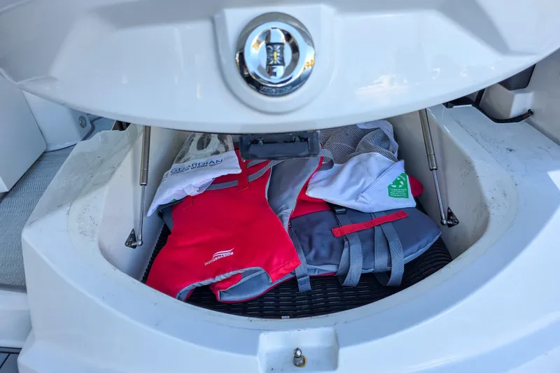 Slide: The Image of 2022 Monterey 295 Sport Yacht docked at a marina, surrounded by calm water and lush greenery. - 20