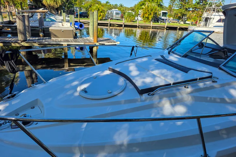 Slide: The Image of 2022 Monterey 295 Sport Yacht emblem on white boat exterior. - 21