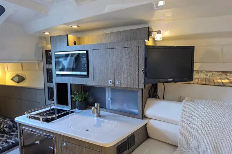 Slide: The Image of 2022 Monterey 295 Sport Yacht bathroom with sink, toilet, and porthole window. - 4