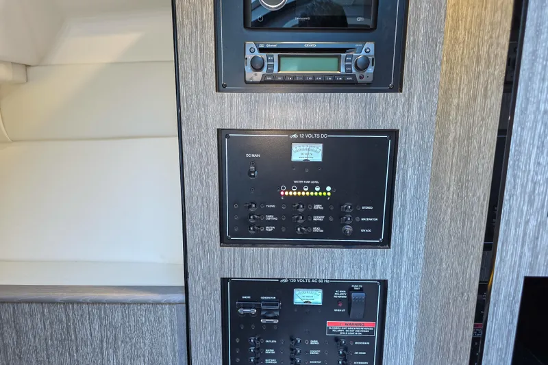 Slide: The Image of 2022 Monterey 295 Sport Yacht interior with geometric-patterned bedding and modern wood paneling. - 7