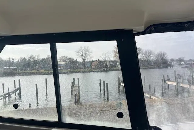 Slide: The Image of Interior view from a 2004 Bayliner 242 Classic boat overlooking a serene waterfront. - 10