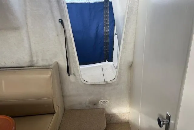 Slide: The Image of Interior of a 2004 Bayliner 242 Classic boat with seating and cabin door. - 15