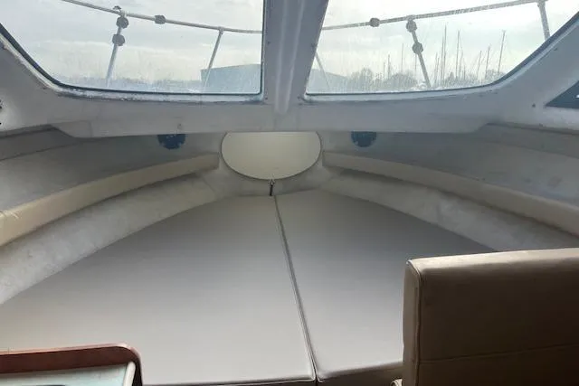 Slide: The Image of 2004 Bayliner 242 Classic boat interior with cushioned seating and large windows. - 19