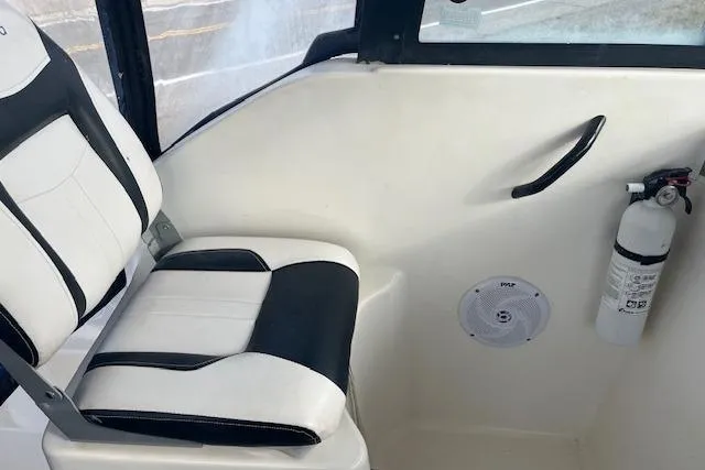 Slide: The Image of 2004 Bayliner 242 Classic interior with seat, fire extinguisher, and speaker. - 9