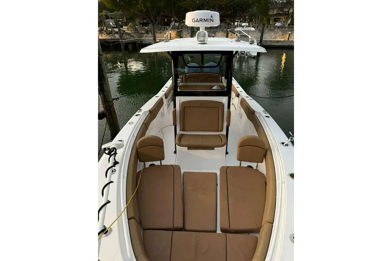 Slide: The Image of 2021 Sea Hunt Gamefish 30 with forward seating, docked by the water. - 12