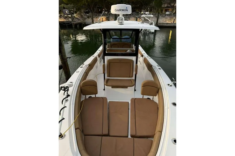 Slide: The Image of 2021 Sea Hunt Gamefish 30 Forward Seating boat with tan cushions, docked by the water. - 15