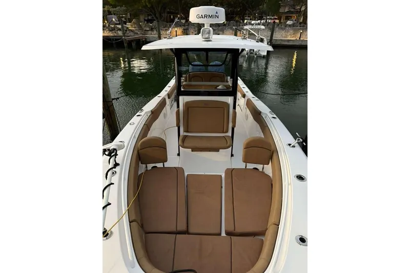 Slide: The Image of 2021 Sea Hunt Gamefish 30 Forward Seating boat with brown cushions, docked by the water. - 22