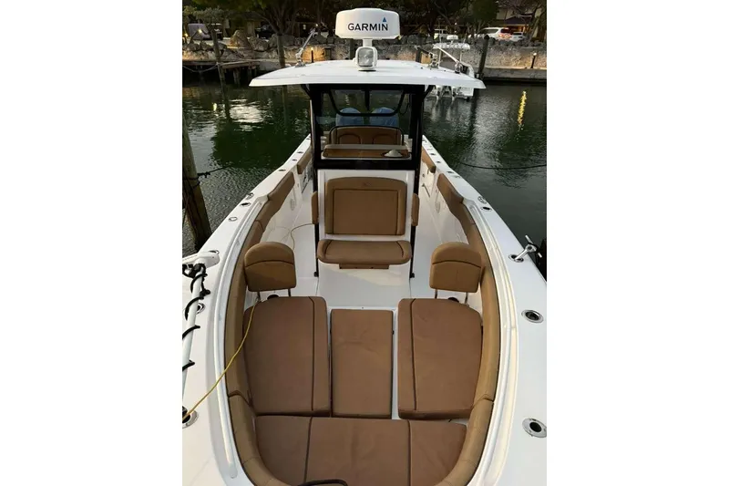 Slide: The Image of 2021 Sea Hunt Gamefish 30 Forward Seating boat with brown cushions, docked by the water. - 25