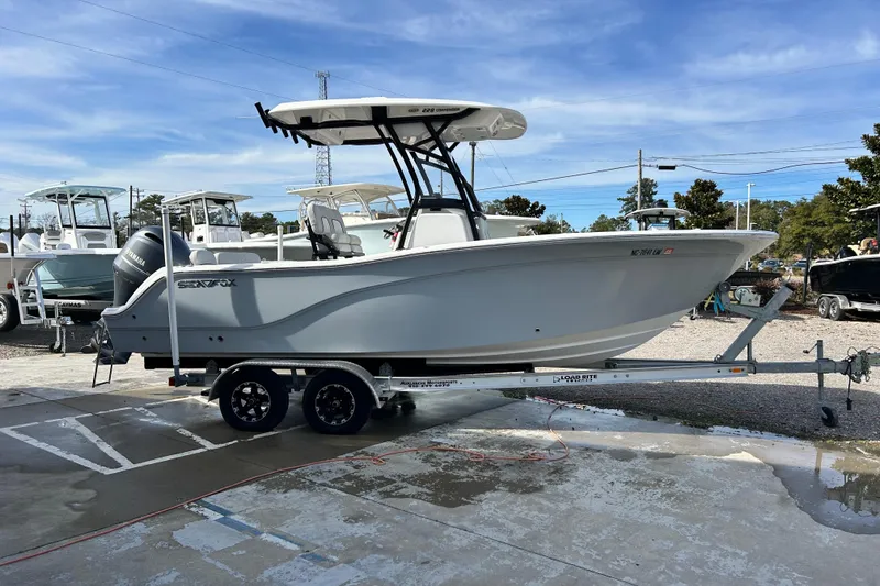 Slide: The Image of 2022 Sea Fox 228 Commander boat on trailer, parked outdoors under blue sky. - 6