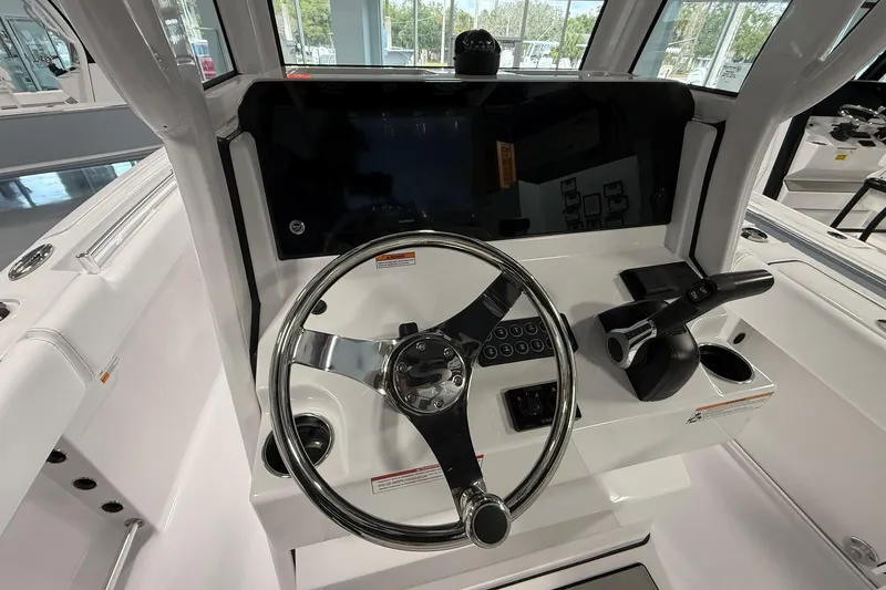 Slide: The Image of 2026 Sportsman Open 232 Center Console boat dashboard with steering wheel and controls. - 5