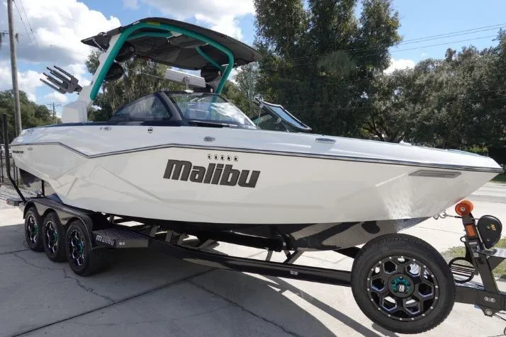 Slide: The Image of 2022 Malibu Wakesetter 25 LSV boat on trailer, parked outdoors. - 2