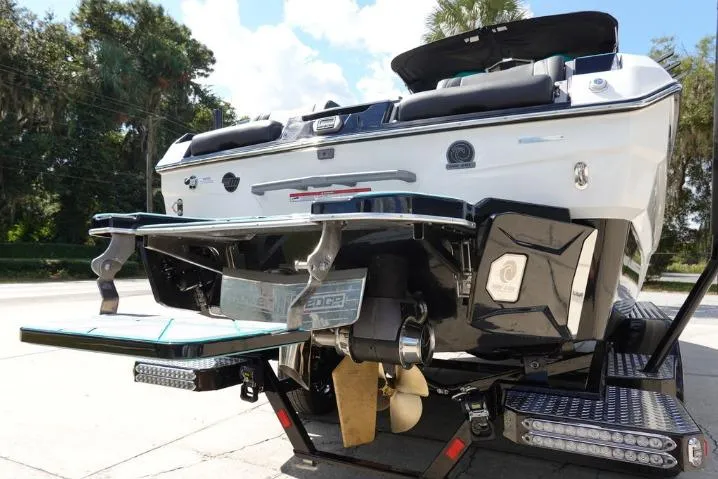 Slide: The Image of 2022 Malibu Wakesetter 25 LSV boat rear view with trailer, outdoors. - 5
