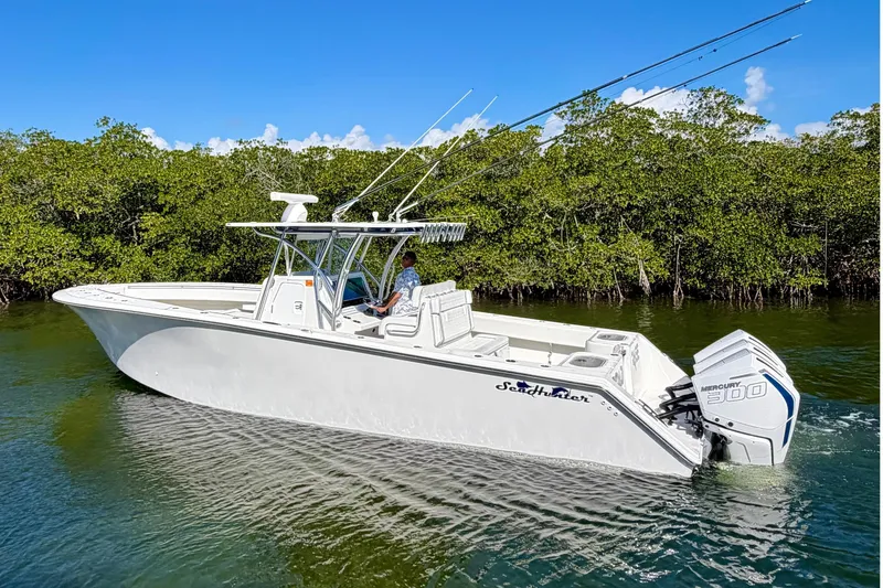 Slide: The Image of 2021 SeaHunter 35 Tournament boat on calm water, surrounded by lush greenery. - 5