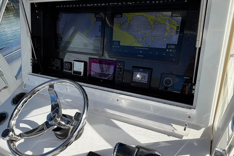 Slide: The Image of 2021 SeaHunter 35 Tournament boat dashboard with navigation screens and steering wheel. - 8
